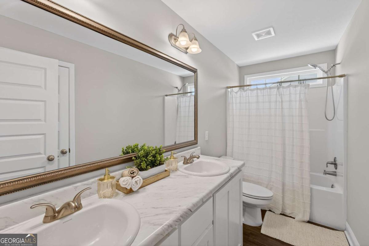 303 Tallulah Bend Ellabell, GA 31308 - Photo 37 of 48 a bathroom with a granite countertop sink and a mirror