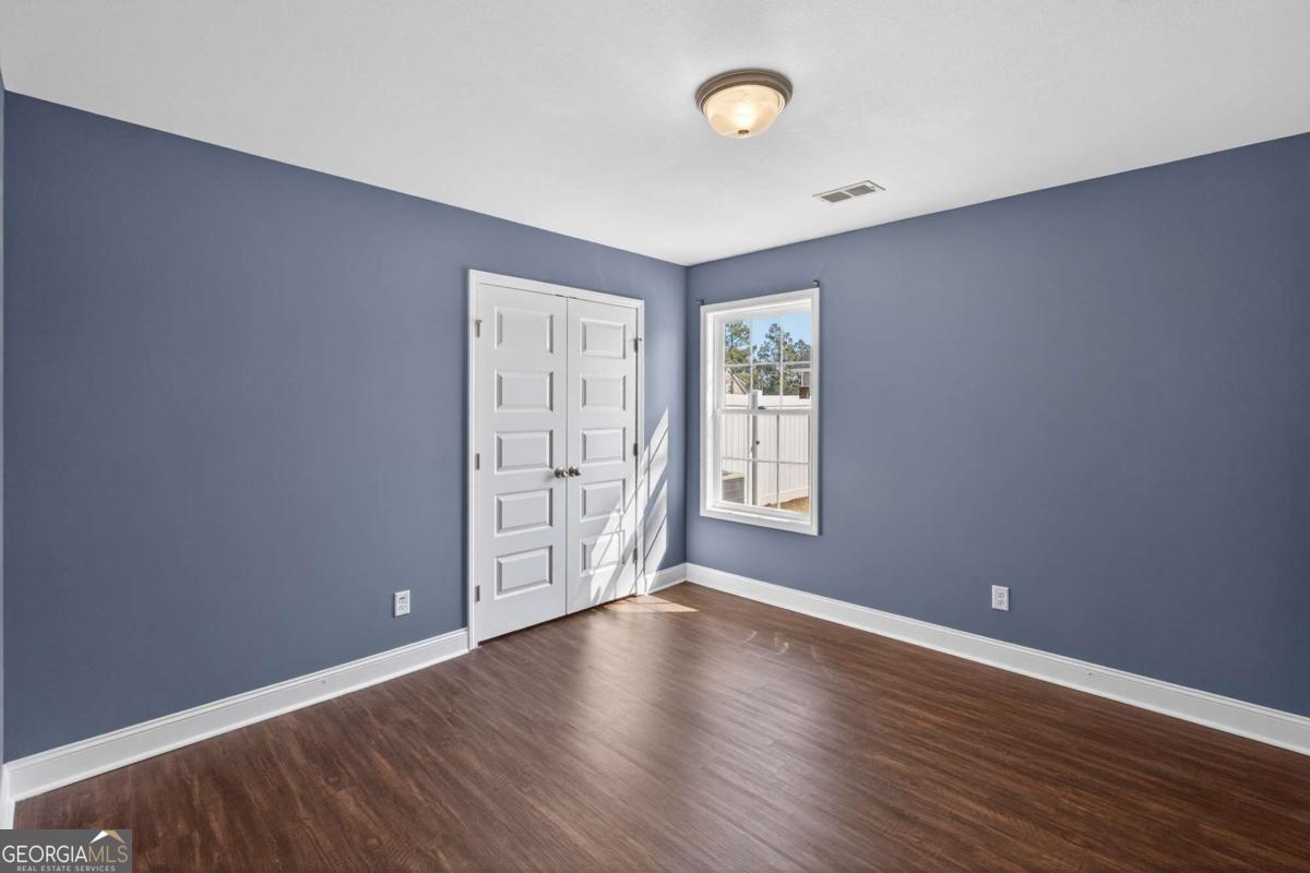303 Tallulah Bend Ellabell, GA 31308 - Photo 39 of 48 an empty room with wooden floor and windows