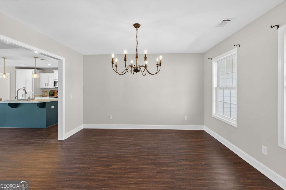 303 Tallulah Bend Ellabell, GA 31308 - Photo 7 of 48 a view of a room with wooden floor chandelier and windows