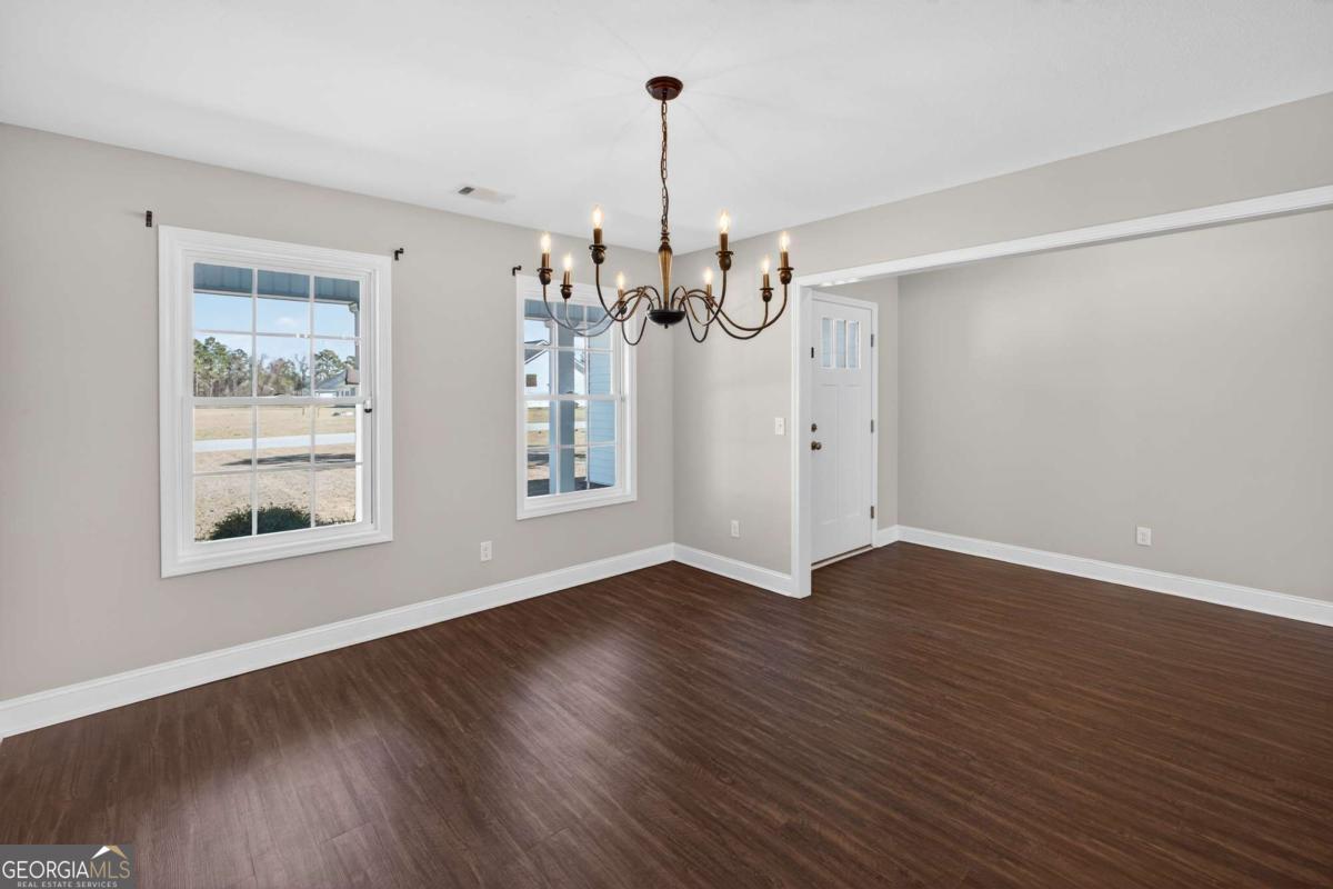 303 Tallulah Bend Ellabell, GA 31308 - Photo 9 of 48 a view of an empty room with wooden floor and a window