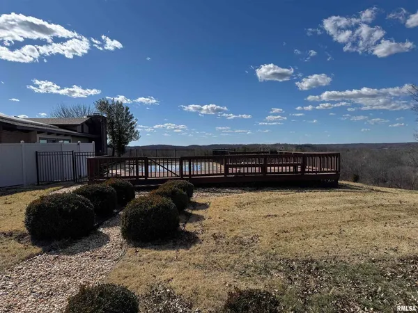 a swimming pool that has lawn chairs with wooden fence