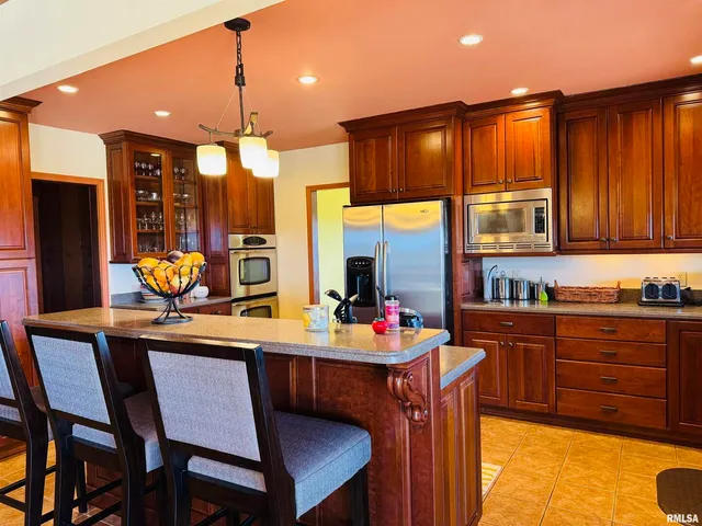 a kitchen with stainless steel appliances granite countertop a refrigerator a sink dishwasher and wooden cabinets with a dishwasher