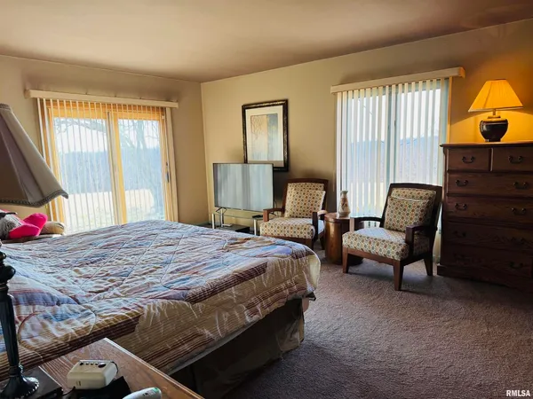 a bedroom with a bed and dresser with mirror