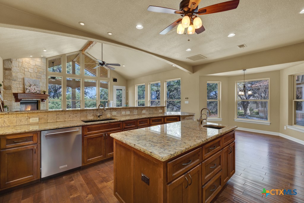7607 Sky Loop Garden Ridge, TX 78266 - Photo 12 of 43 a kitchen with granite countertop center island a sink stainless steel appliances and cabinets