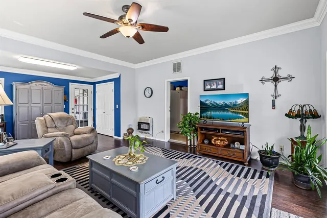 a living room with furniture a flat screen tv and a potted plant