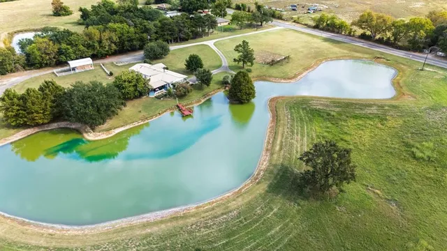 a view of a swimming pool with a yard and lake