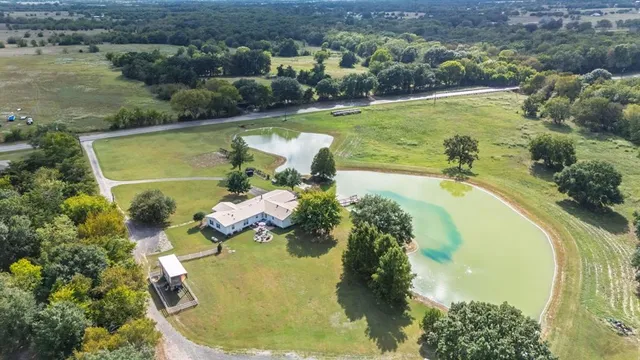 a swimming pool with trees in the background and a yard