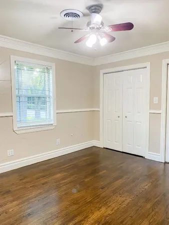 a view of a big room with wooden floor and windows