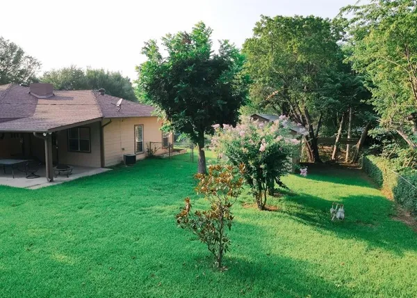 a view of a house with backyard and a tree