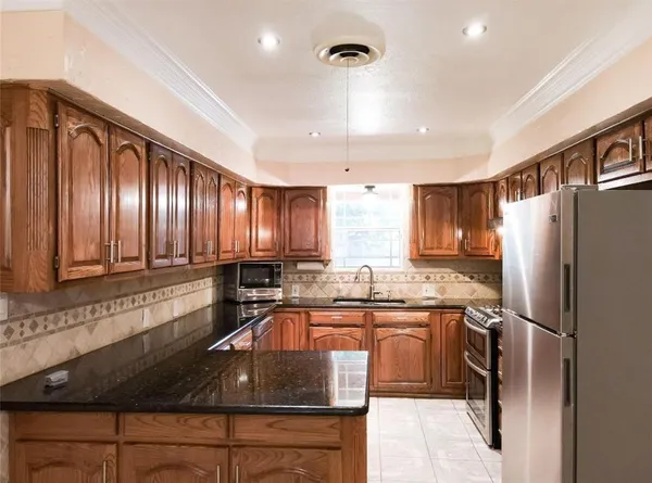 a kitchen with kitchen island granite countertop a sink stainless steel appliances and cabinets