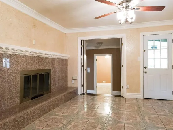 a view of an empty room with a fireplace and a window