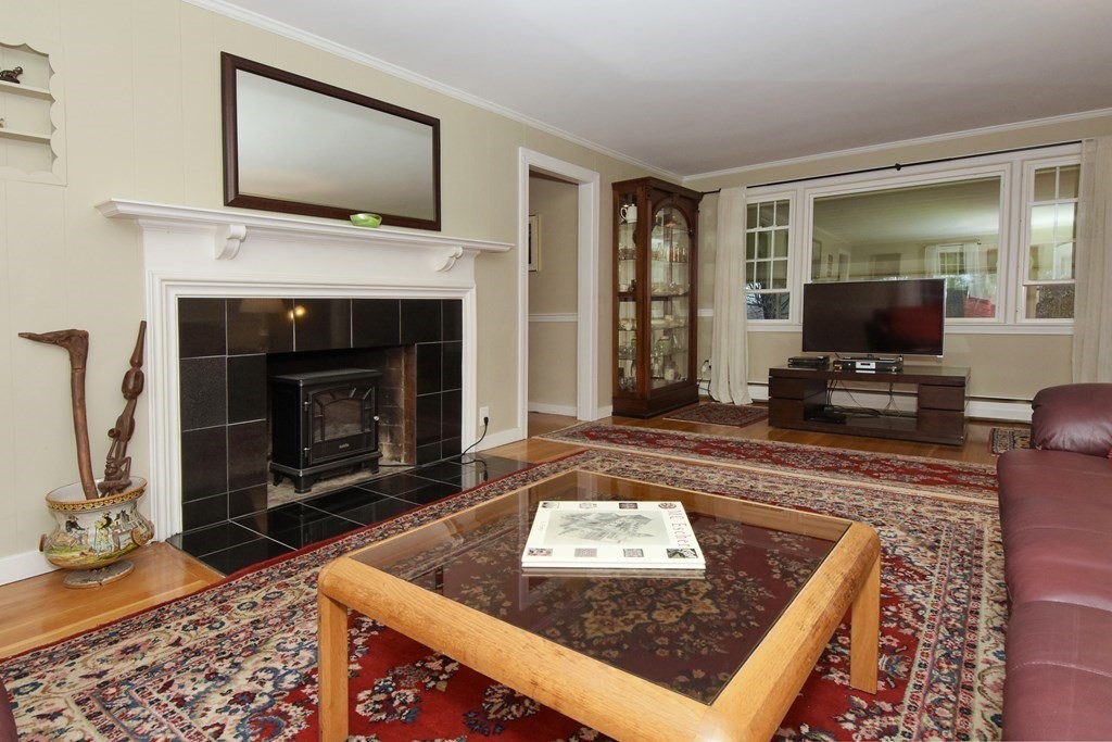 45 McGregory Road Sturbridge, MA 01566 - Photo 7 of 36 a living room with furniture a flat screen tv and a fireplace