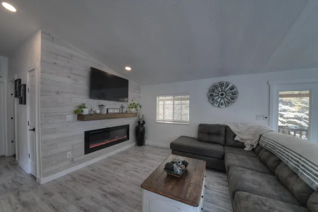 a living room with furniture a flat screen tv and a fireplace