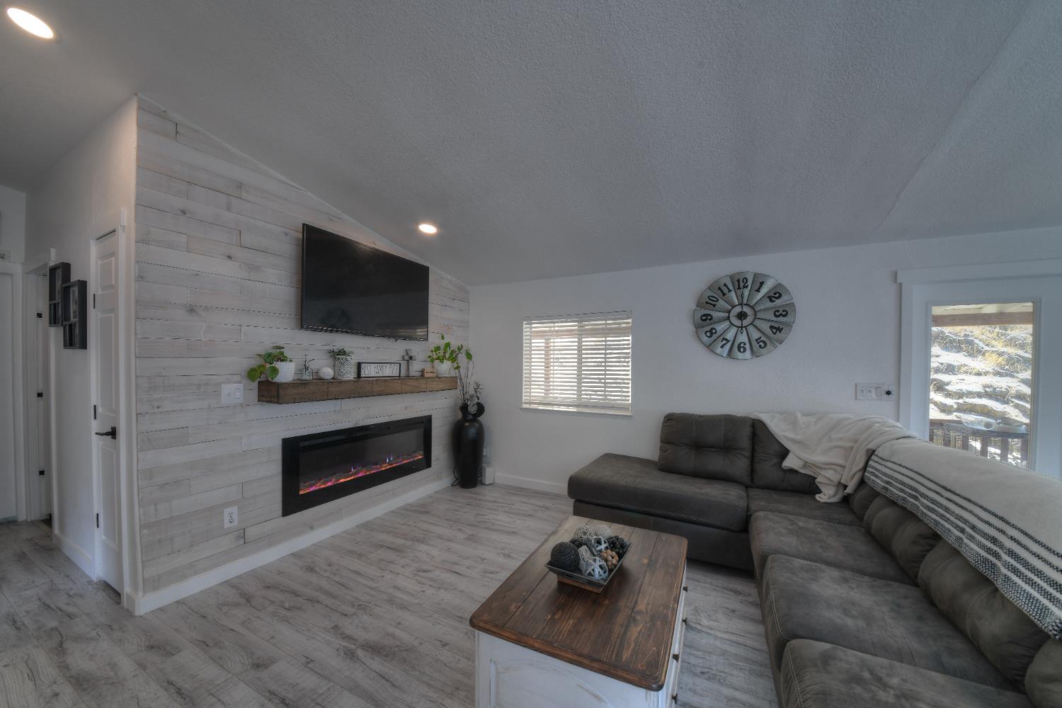 a living room with furniture a flat screen tv and a fireplace