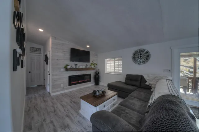 a living room with furniture a fireplace and a flat screen tv