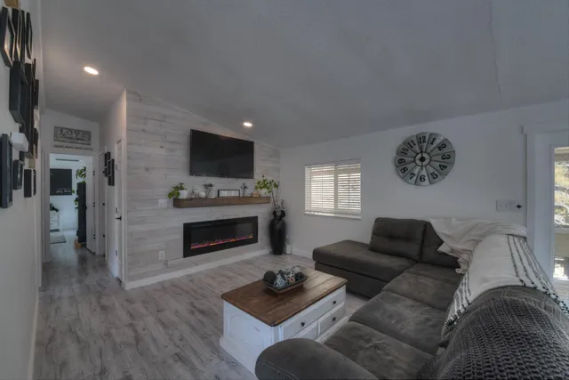 a living room with furniture a fireplace and a flat screen tv