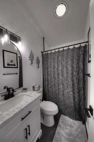 a bathroom with a granite countertop sink toilet and shower