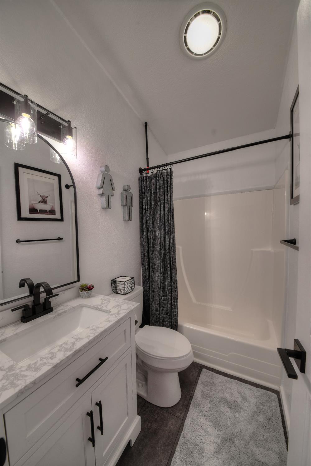 17045 Table Mountain Road Jamestown, CA 95327 - Photo 23 of 59 a bathroom with a granite countertop sink toilet a mirror a vanity and shower