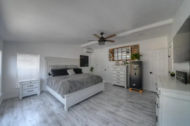 a bedroom with a bed and a flat tv screen on dresser