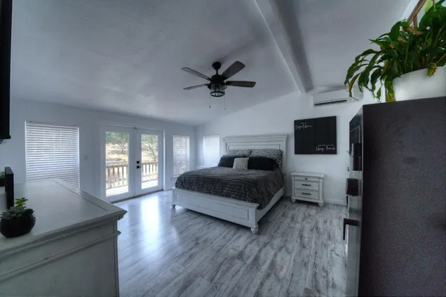 a bedroom with a bed and a potted plant on the dresser