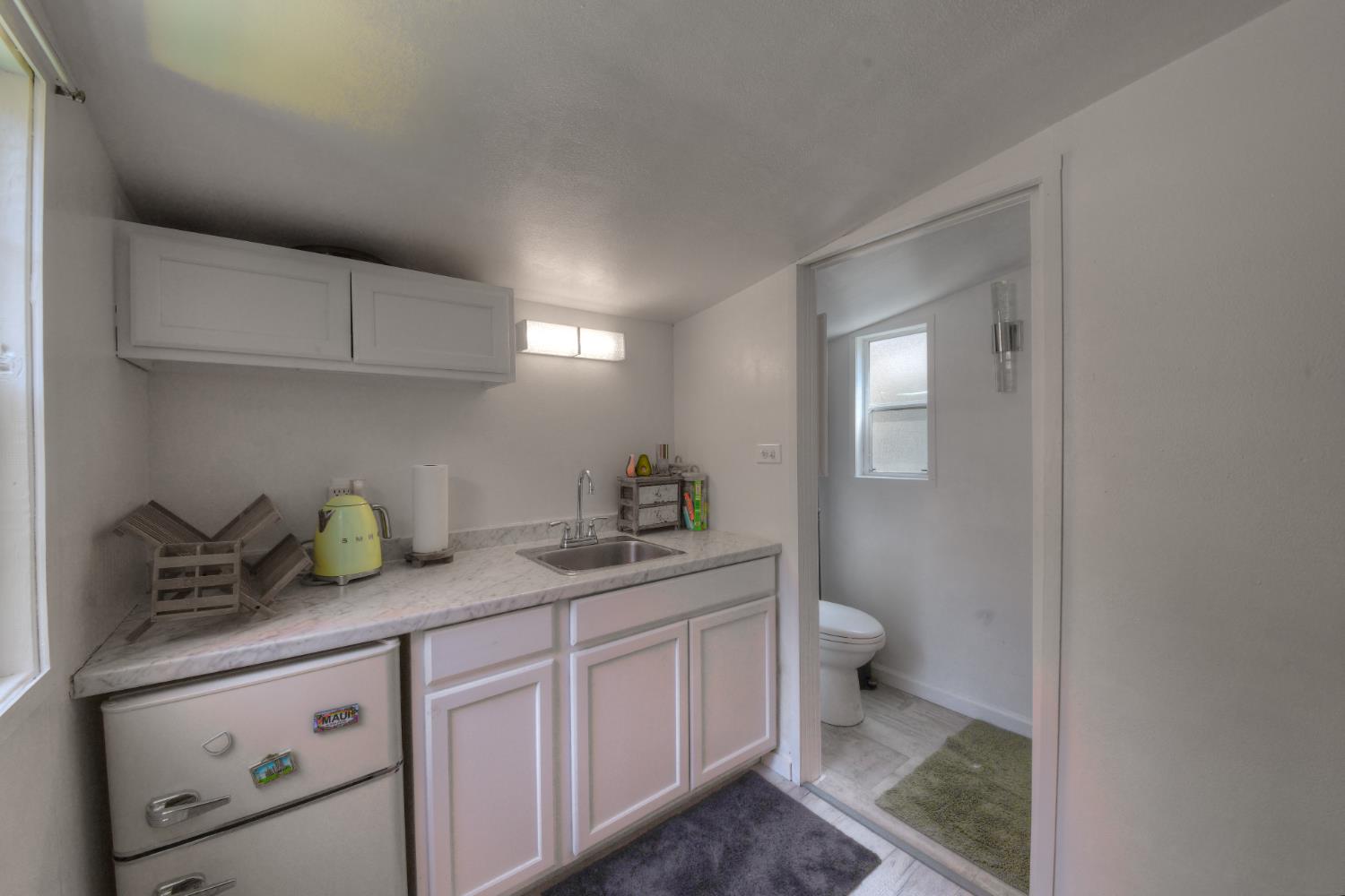 17045 Table Mountain Road Jamestown, CA 95327 - Photo 47 of 59 a bathroom with a granite countertop sink a toilet and a mirror