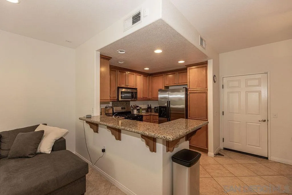 5527 Old Ranch Road, Unit 44 Oceanside, CA 92057 - Photo 8 of 34 a kitchen with stainless steel appliances granite countertop a sink refrigerator and cabinets