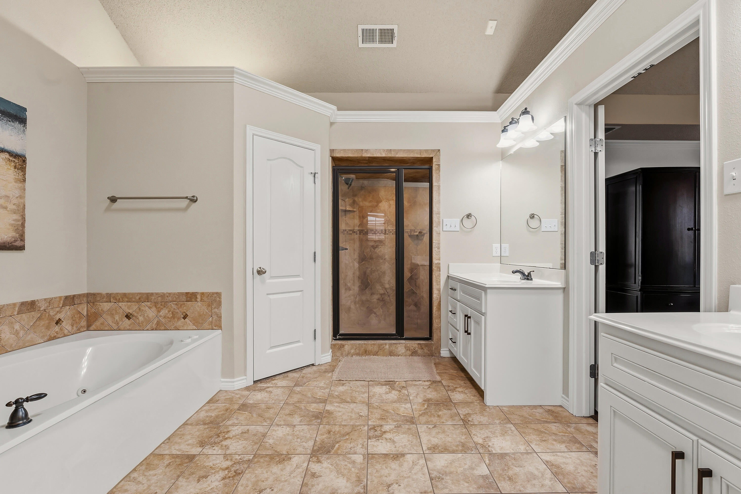 6903 87th Street Lubbock, TX 79424 - Photo 15 of 35 a bathroom with a tub sink and mirror