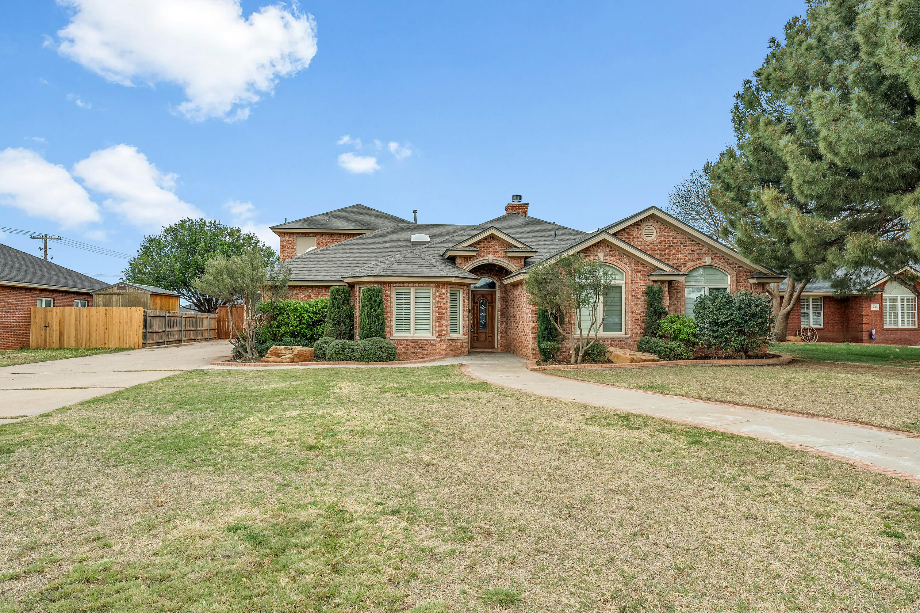 6903 87th Street Lubbock, TX 79424 - Photo 2 of 35 a front view of a house with a yard and garage