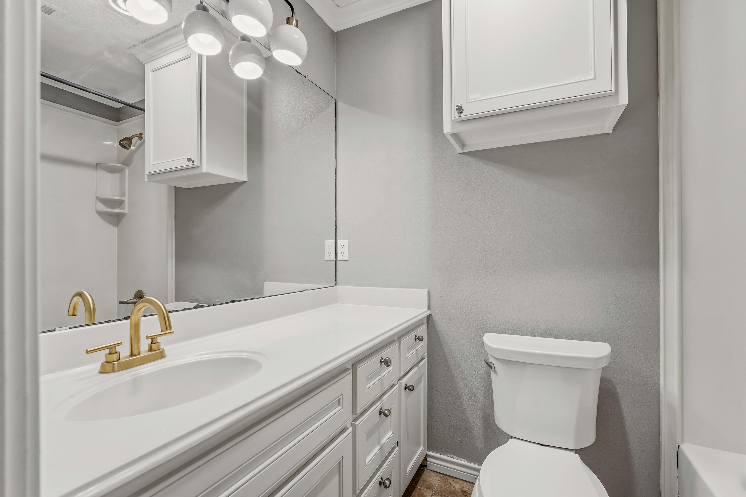 6903 87th Street Lubbock, TX 79424 - Photo 21 of 35 a bathroom with a toilet sink and mirror