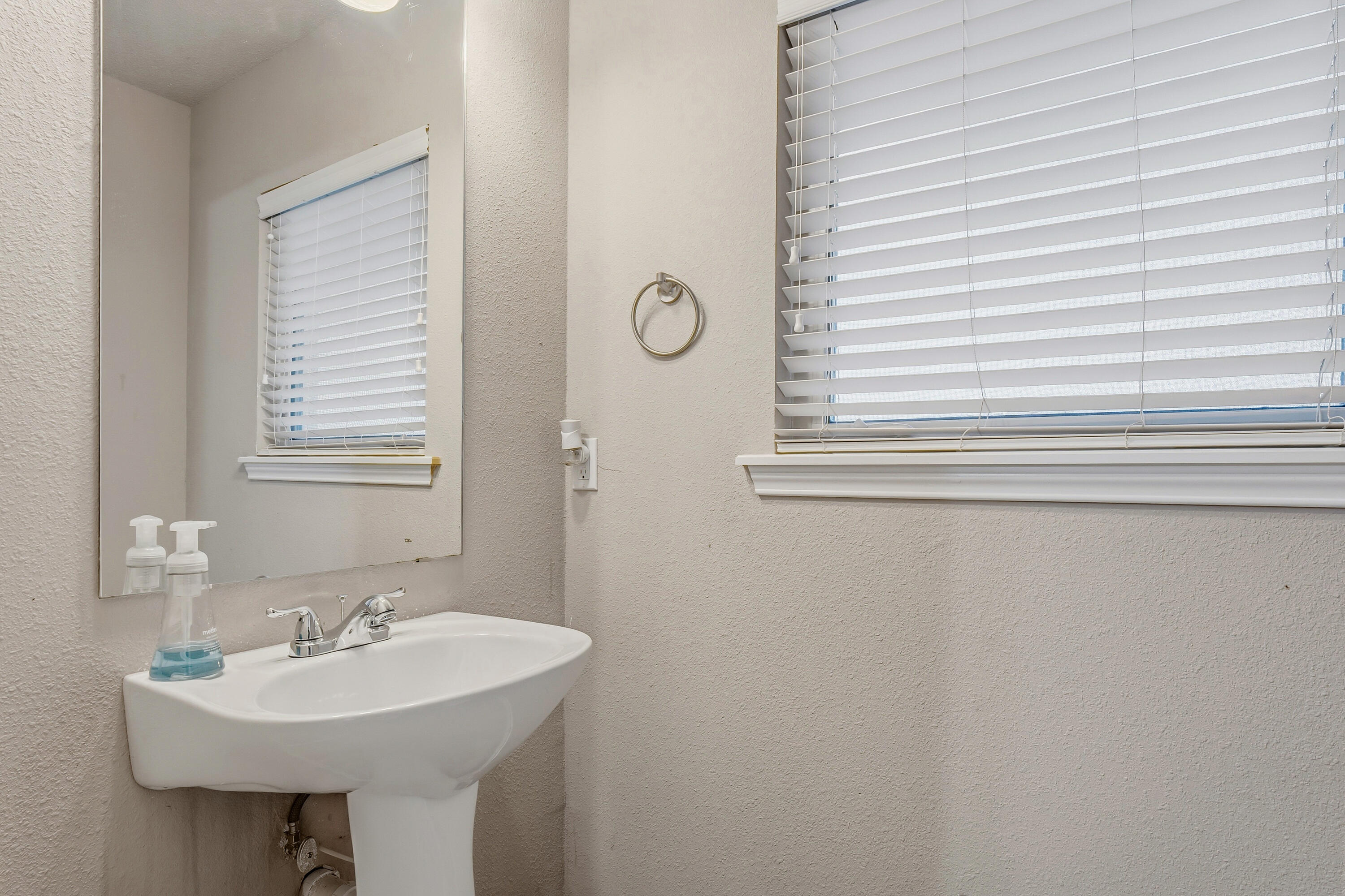 6903 87th Street Lubbock, TX 79424 - Photo 24 of 35 a bathroom with a sink a mirror and a window