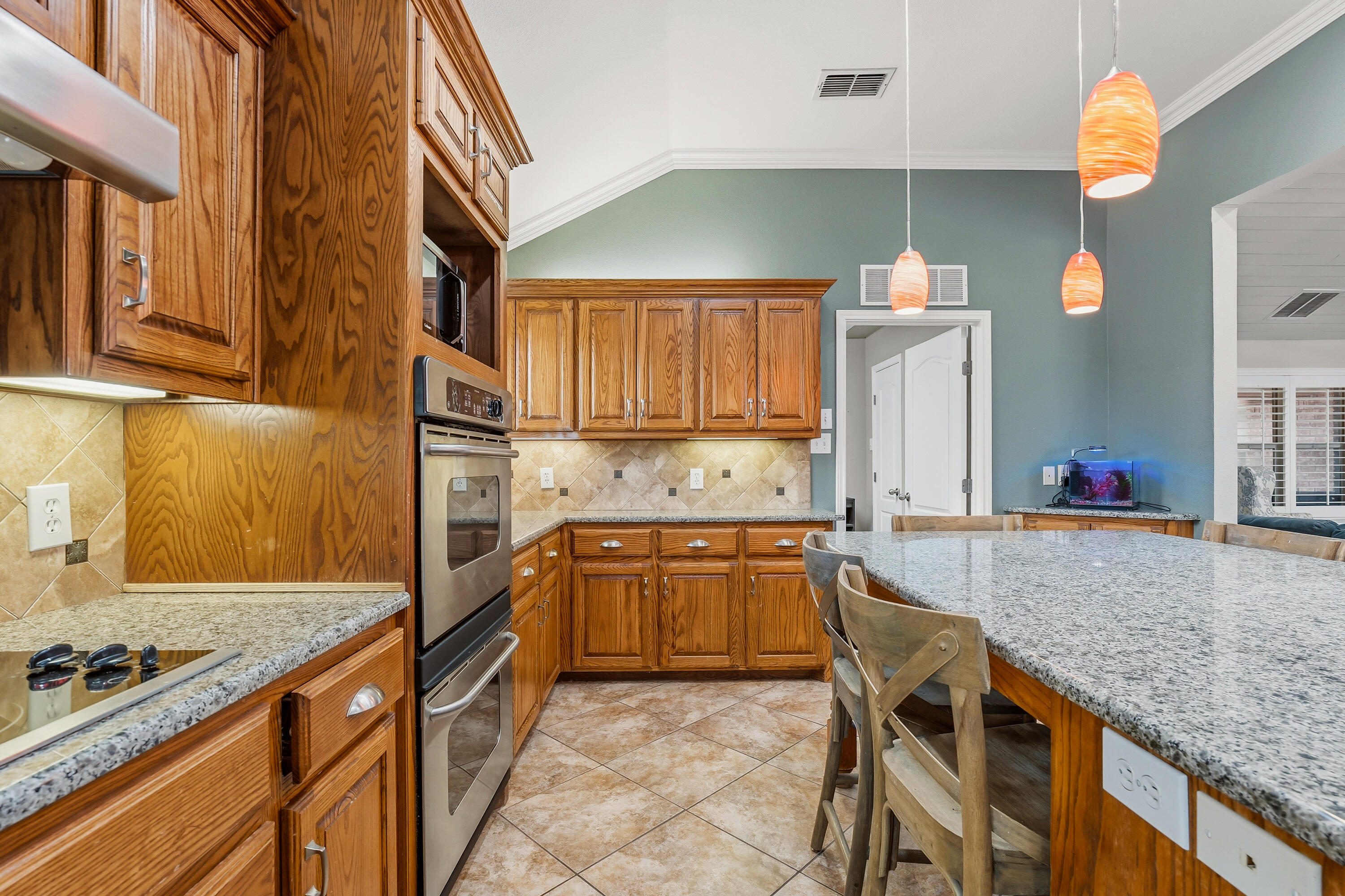 6903 87th Street Lubbock, TX 79424 - Photo 10 of 35 a kitchen with granite countertop a sink and a stove