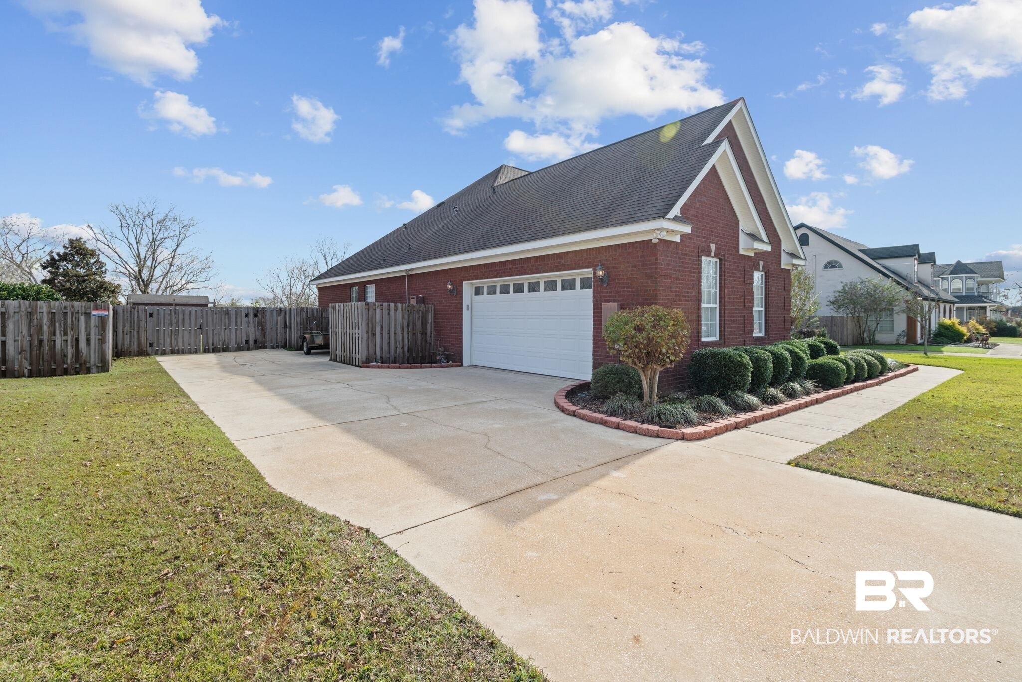4771 Pecan Ridge East Mobile, AL 36619 - Photo 4 of 48 View of side of property with brick siding, concrete driveway, roof with shingles, and a garage