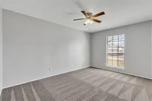 an empty room with windows and ceiling fan
