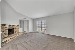 an empty room with fireplace and windows