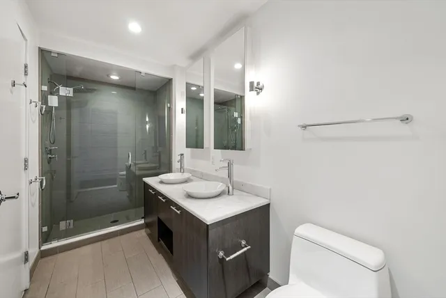 a bathroom with a sink a toilet and shower