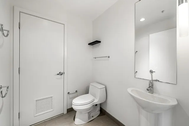a bathroom with a toilet a sink and mirror