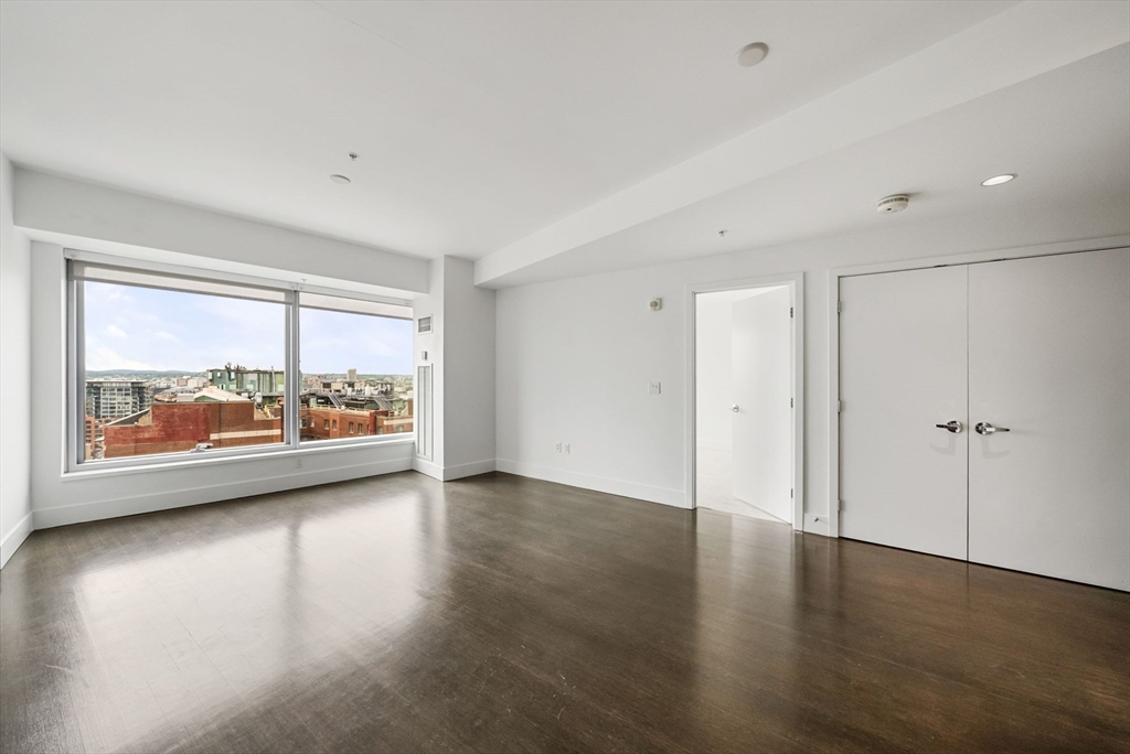 110 Stuart Street, Unit 19H Boston, MA 02116 - Photo 5 of 24 wooden floor in an empty room with a window
