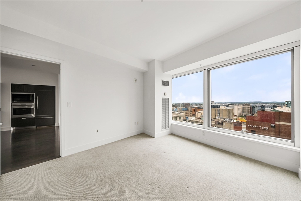 110 Stuart Street, Unit 19H Boston, MA 02116 - Photo 6 of 24 an empty room with large windows