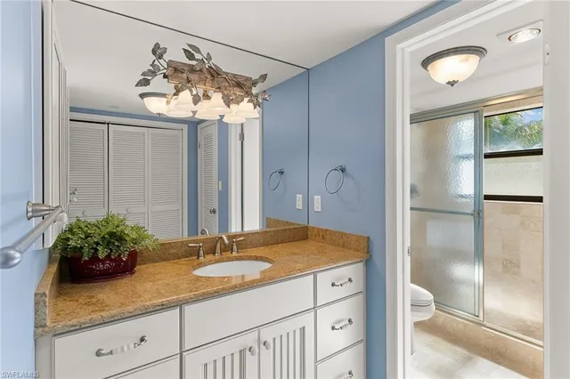 a bathroom with a granite countertop sink a mirror and a shower