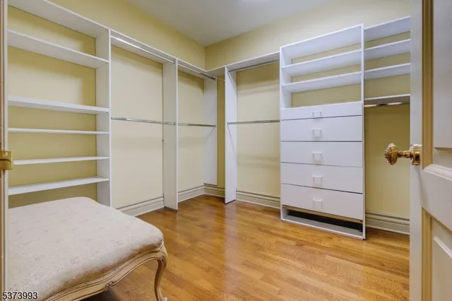 a room with walk in closet and wooden floor