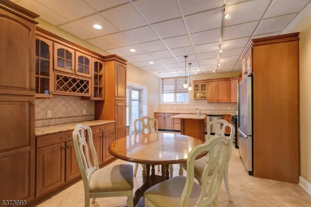 a dinning area with stainless steel appliances granite countertop a dining table and chairs with wooden floor