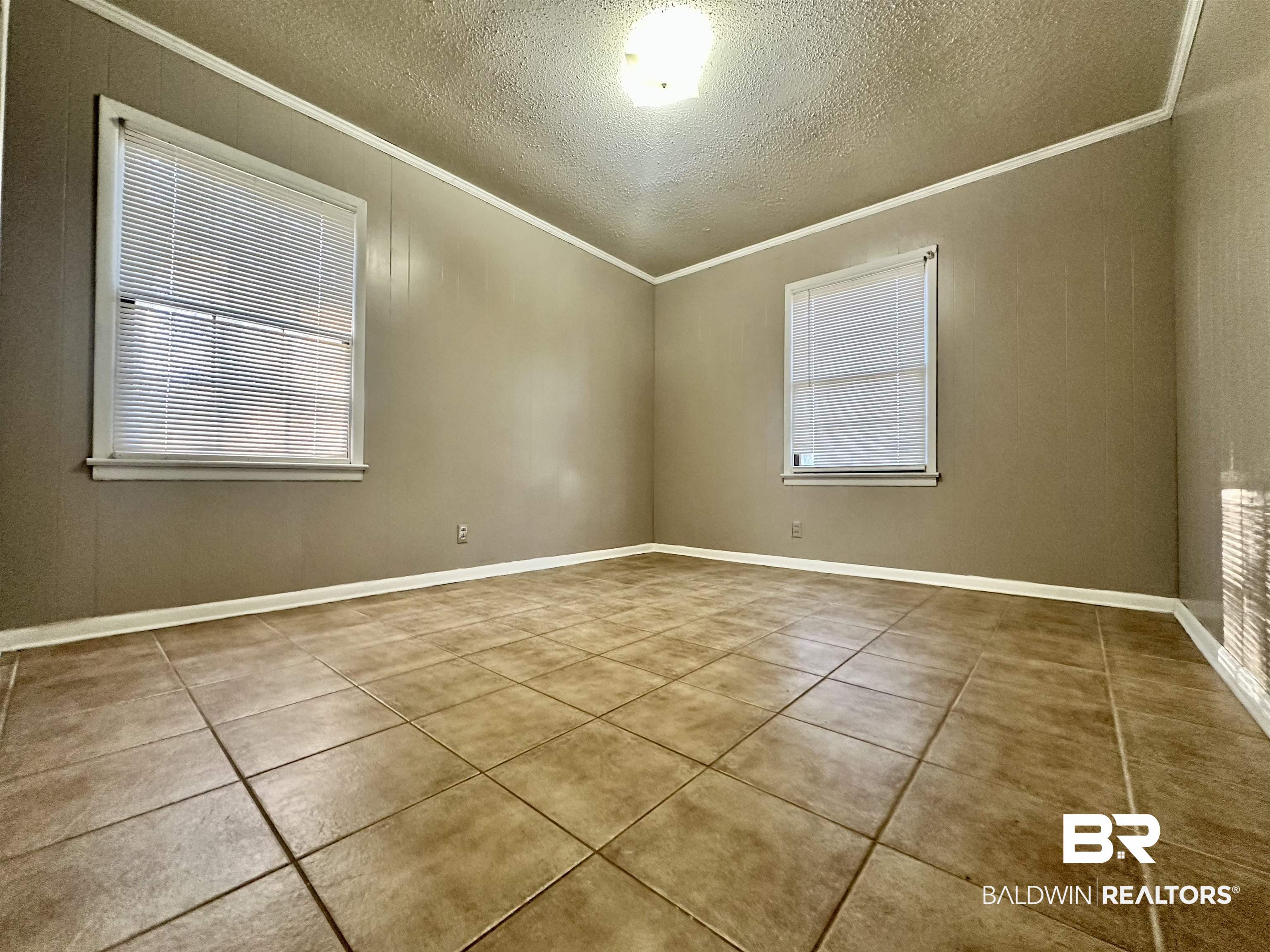 2664 Sowell Road Brewton, AL 36426 - Photo 10 of 12 Unfurnished room with a textured ceiling, light tile patterned floors, and ornamental molding
