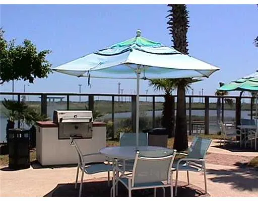 a patio with a table and chairs under an umbrella