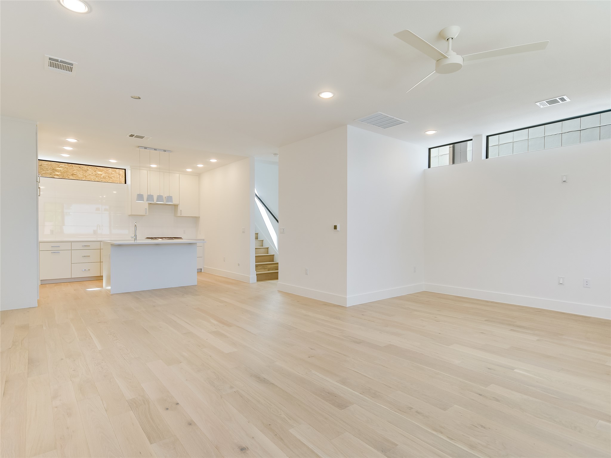 3406 East 17th Street, Unit 3 Austin, TX 78721 - Photo 11 of 27 an empty room with a kitchen and a ceiling fan