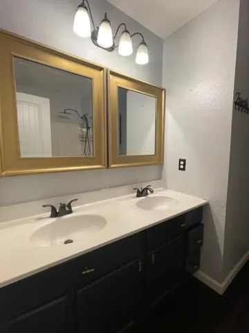 a bathroom with a double vanity sink and a mirror