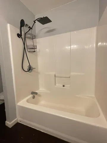 a bathroom with a bath tub with a shower