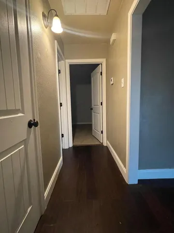 a view of a hallway with wooden floor