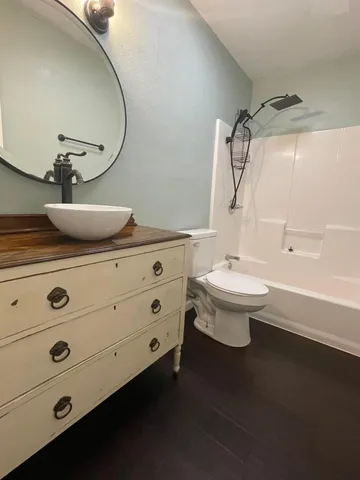 a bathroom with a sink a toilet and shower
