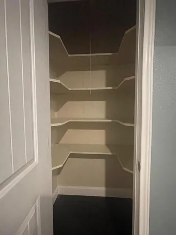 a view of walk in closet with empty racks