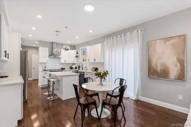 a kitchen with a dining table chairs and refrigerator